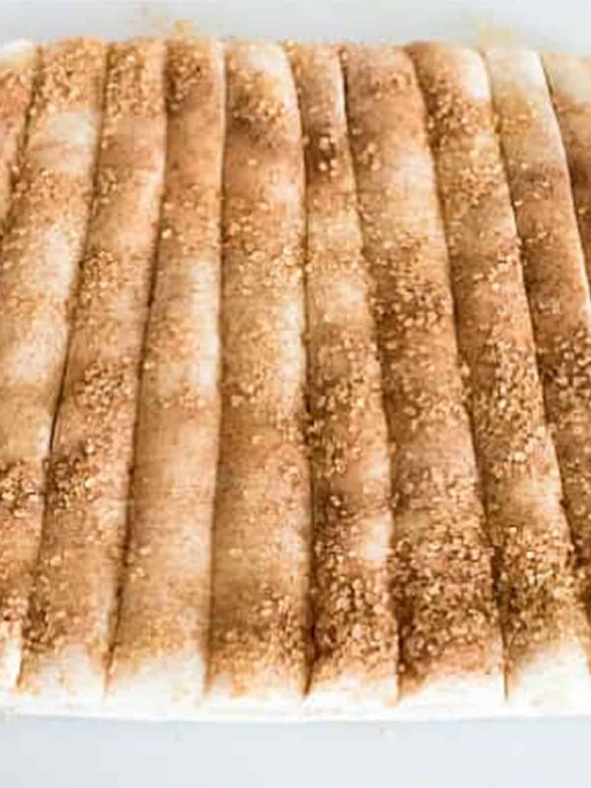 Layered pie crust cut into thin strips for twisting into cinnamon apple twists.