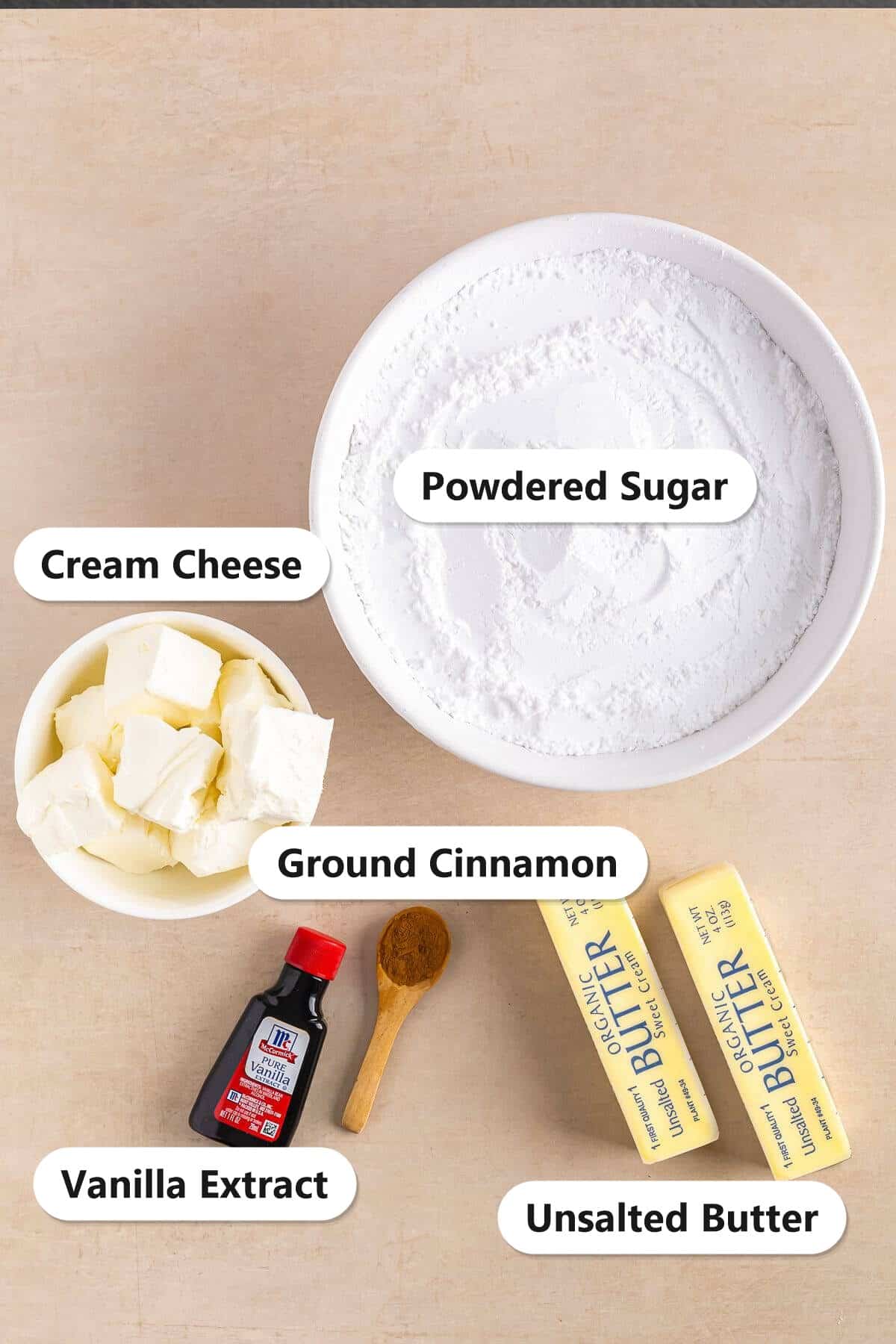 Labeled ingredients for Cinnamon Cream Cheese Frosting including cream cheese, unsalted butter, powdered sugar, vanilla extract, and ground cinnamon.