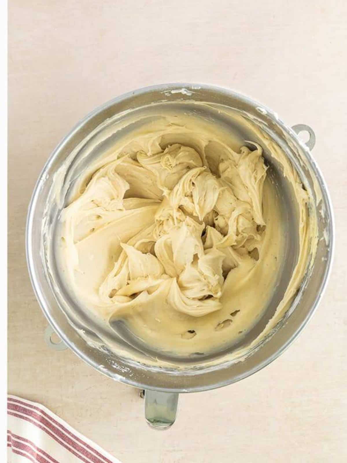 Light and fluffy Cinnamon Cream Cheese Frosting whipped in the stand mixer bowl.