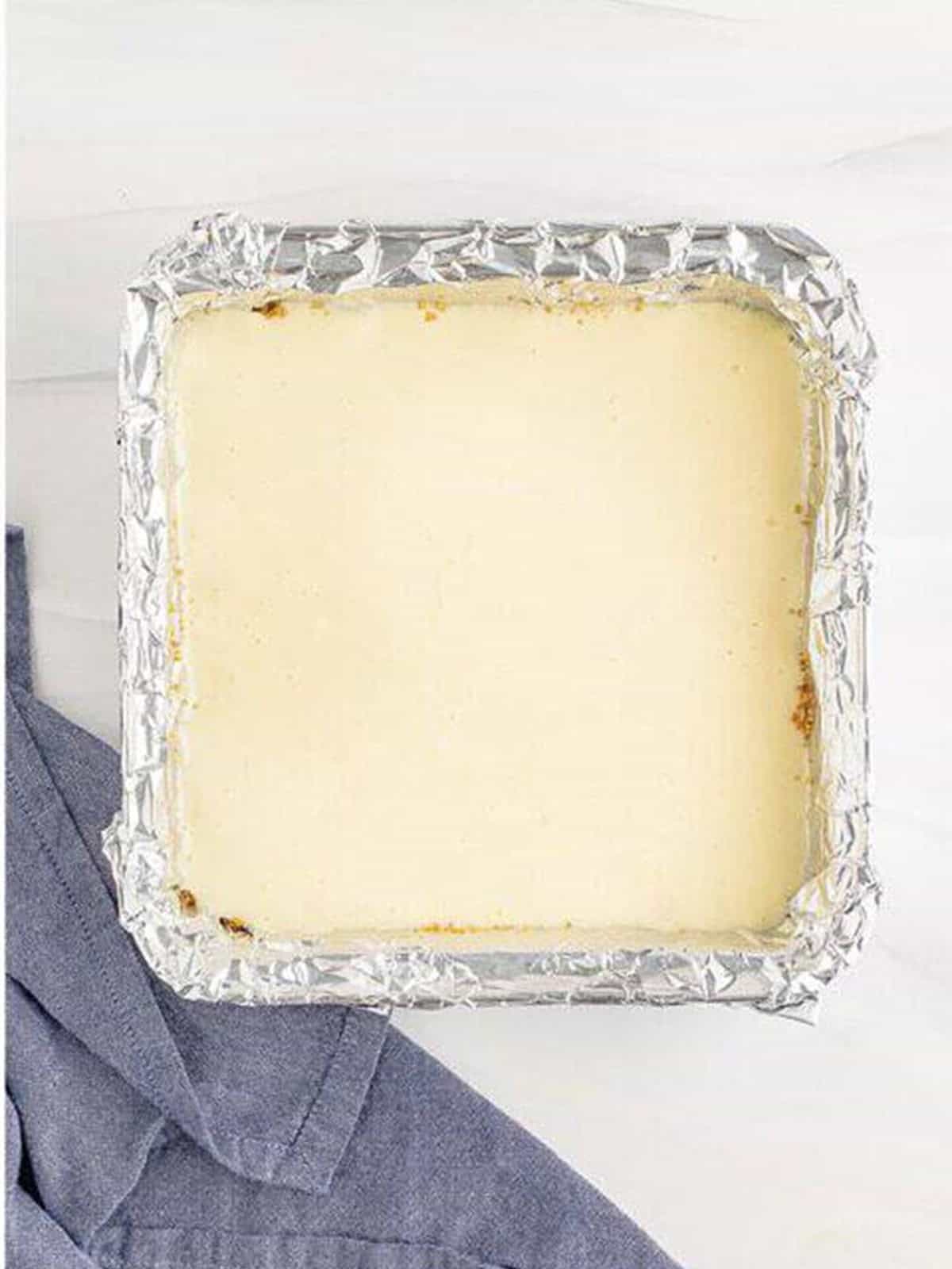 The creamy coconut cheesecake filling poured over the baked crust in the foil lined pan.