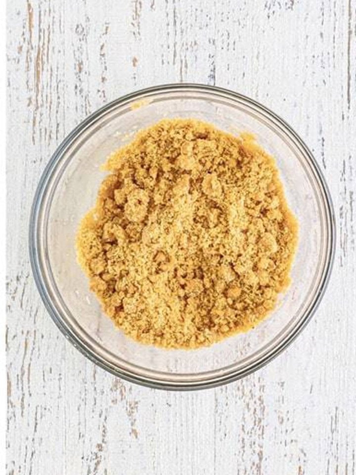 Cinnamon brown sugar crumble mixed with a fork in a glass bowl.