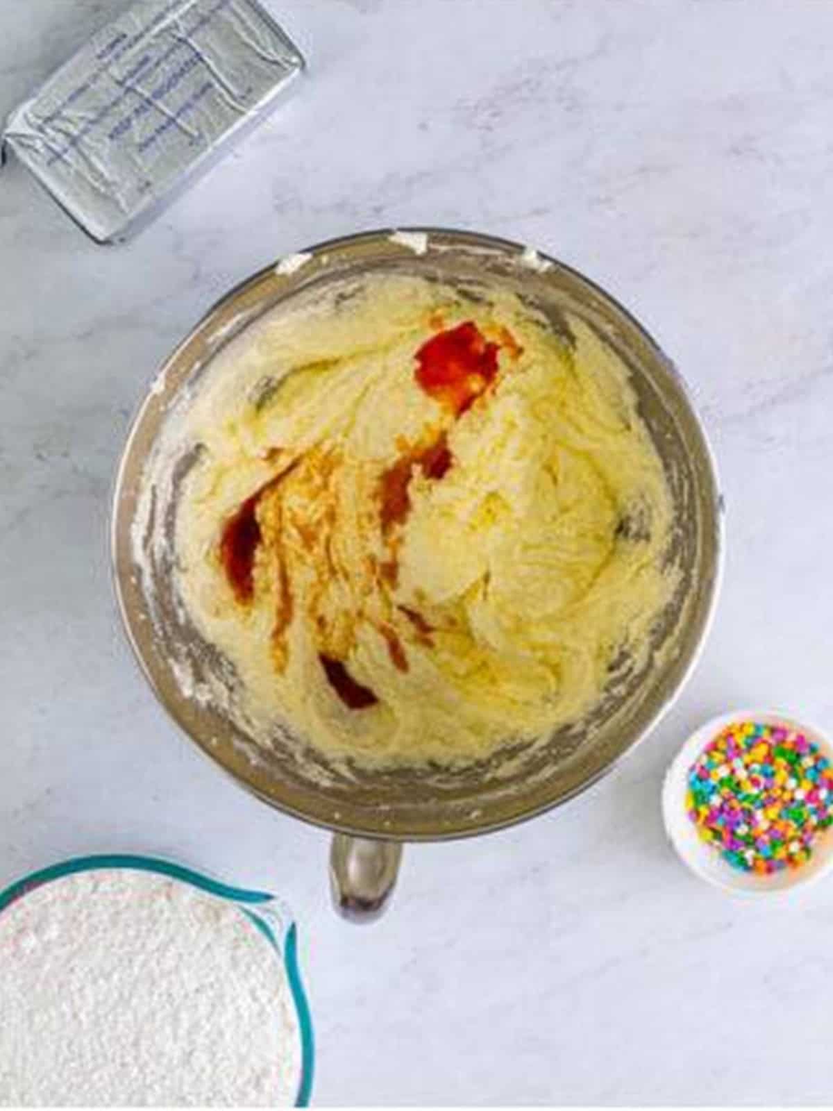 Egg whites and cake batter and vanilla extracts added to the creamed butter and sugar.
