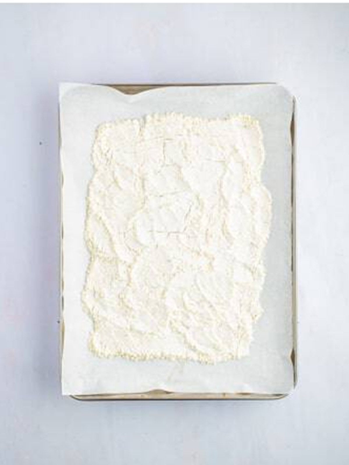 Heat treated flour spread on a parchment lined sheet tray.