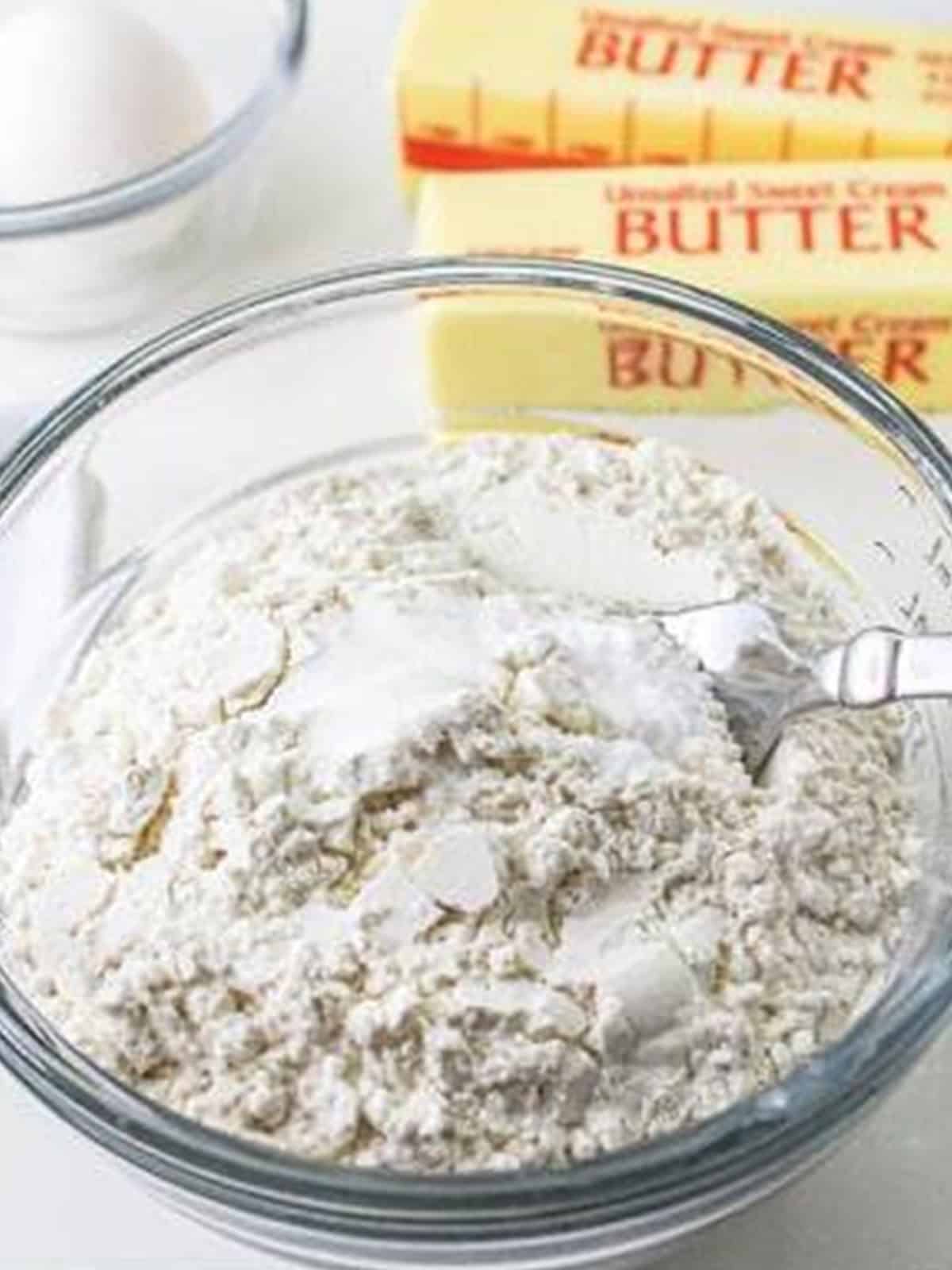 Flour, baking soda, and salt whisked together in a glass bowl for blossom cookies.