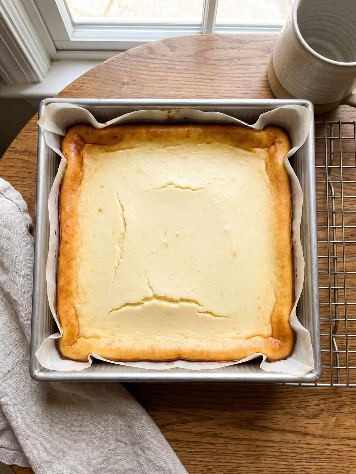 Baked cheesecake bars cooling in the pan.