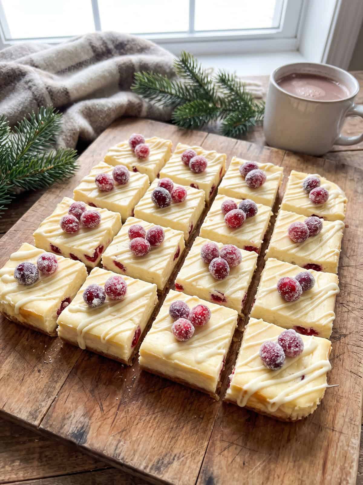 Cranberry Cheesecake Bars topped with sugared cranberries and white chocolate drizzle.