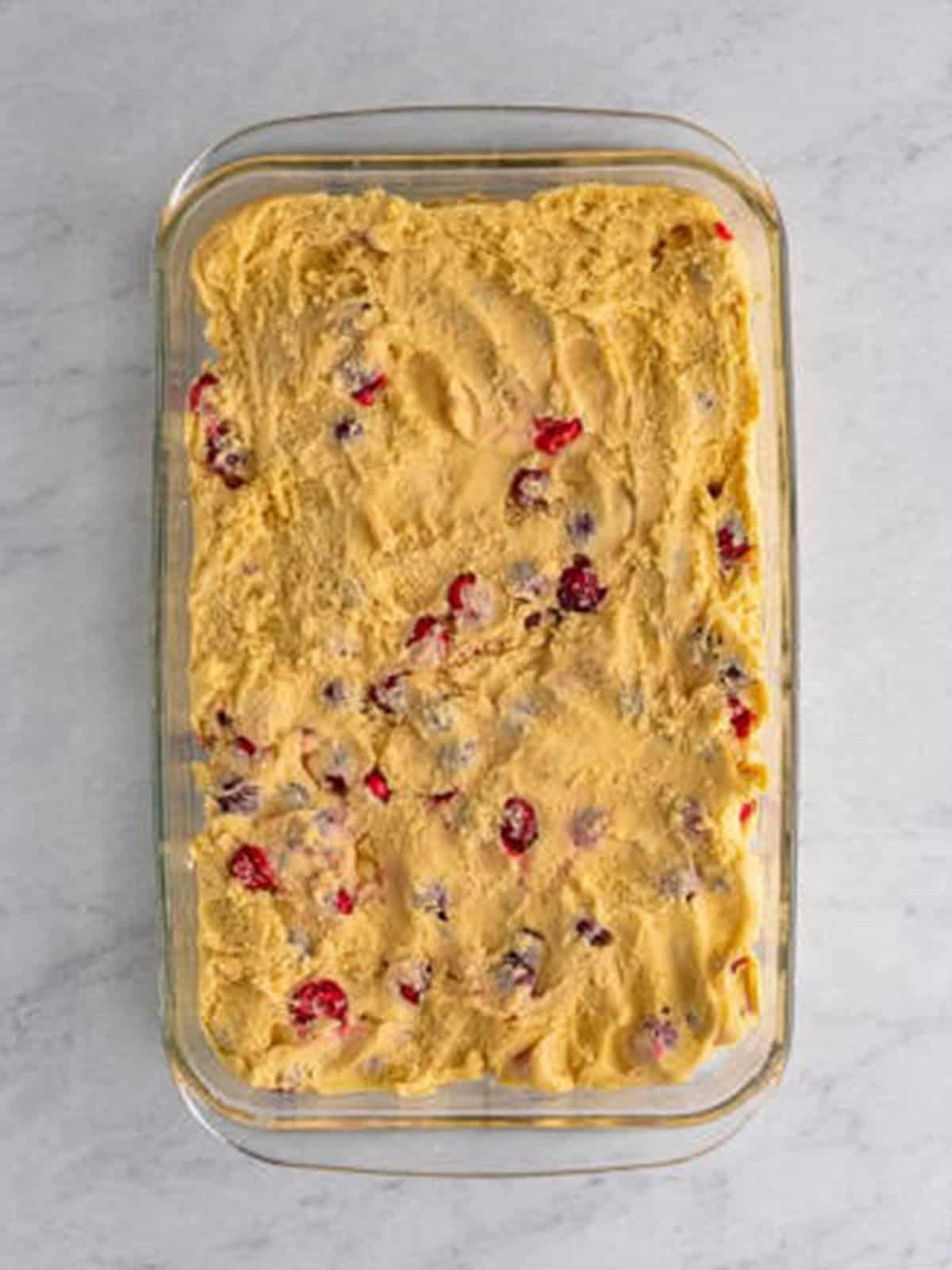 Cranberry Coffee Cake batter spread into a glass baking dish.