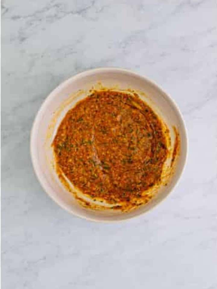 Eggs, ketchup, breadcrumbs, and seasonings mixed in a bowl for Cranberry Meatballs.