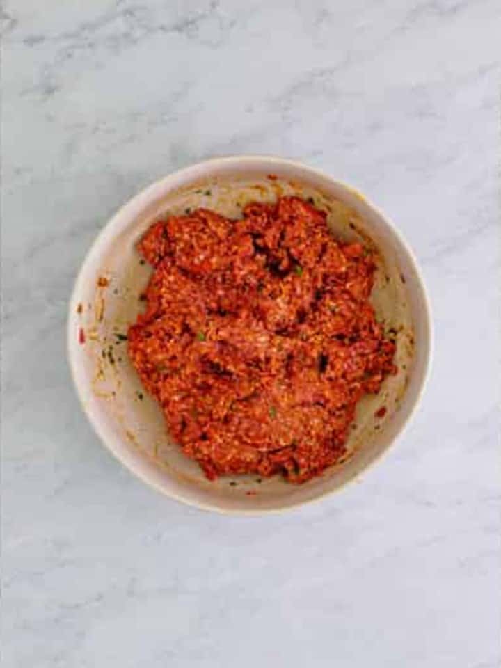 Ground beef mixed into the seasoning base for Cranberry Meatballs.
