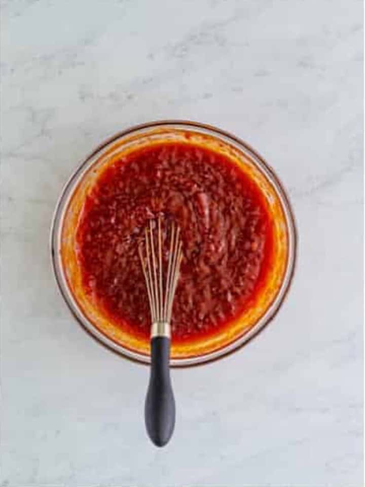 Whisking the jellied cranberry sauce, chili sauce, and brown sugar together.