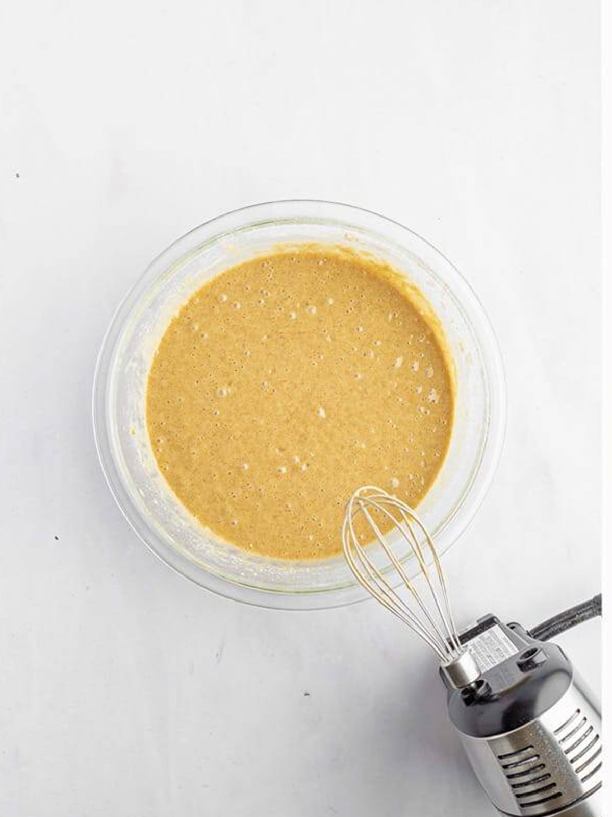 Cream cheese filling whisked smooth in a glass bowl for cream cheese crumb cake.
