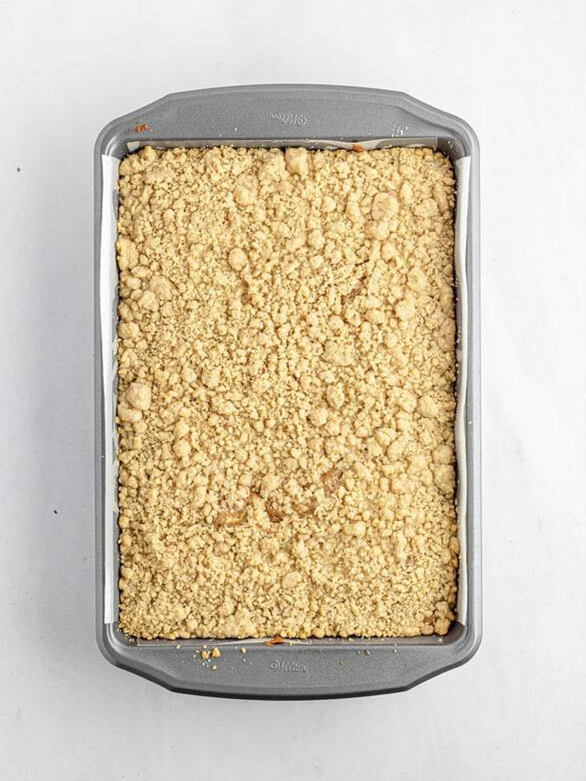 Golden baked cream cheese crumb cake with crumb topping in the pan.