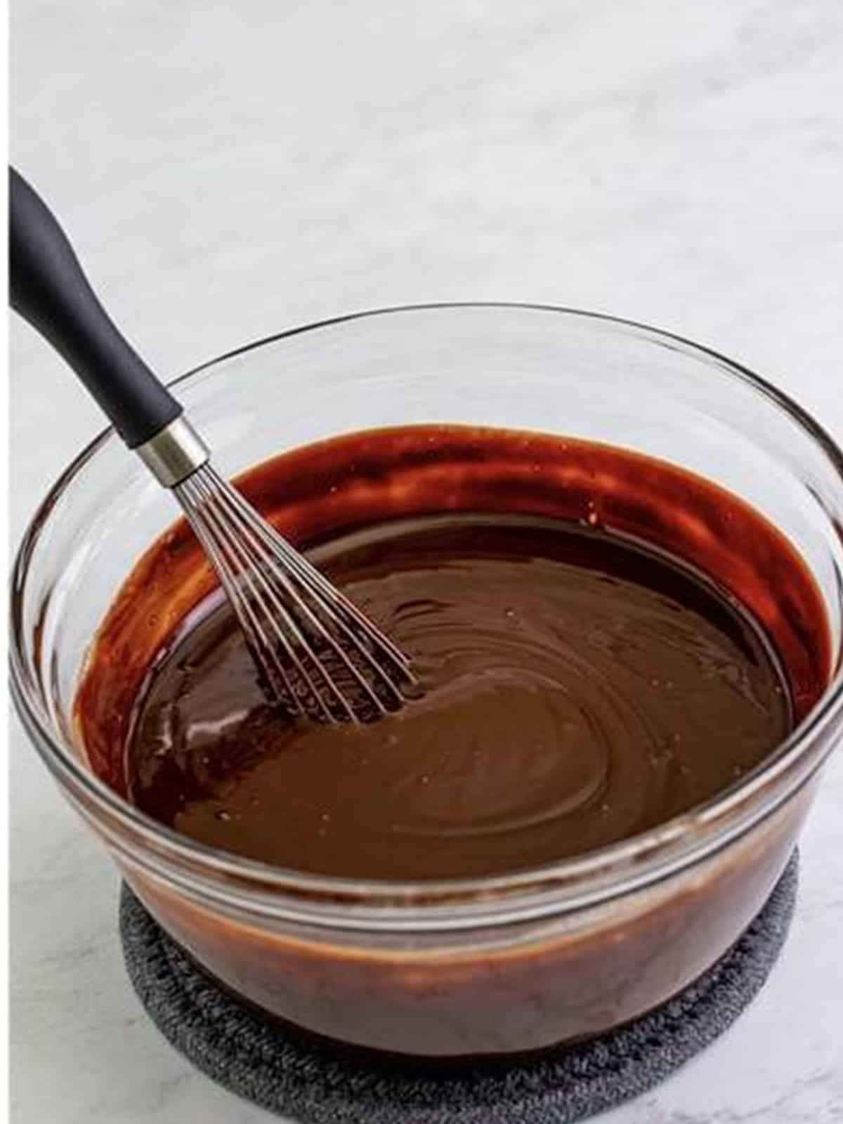 Chocolate ganache frosting whisked until smooth and pipeable for Crumbl Chocolate Cupcake Cookies.