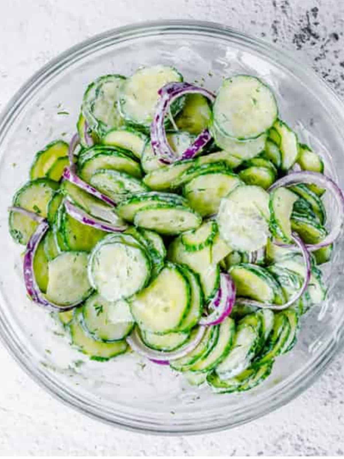 Cucumber Dill Salad tossed until every slice is coated in the creamy dressing, ready to chill.