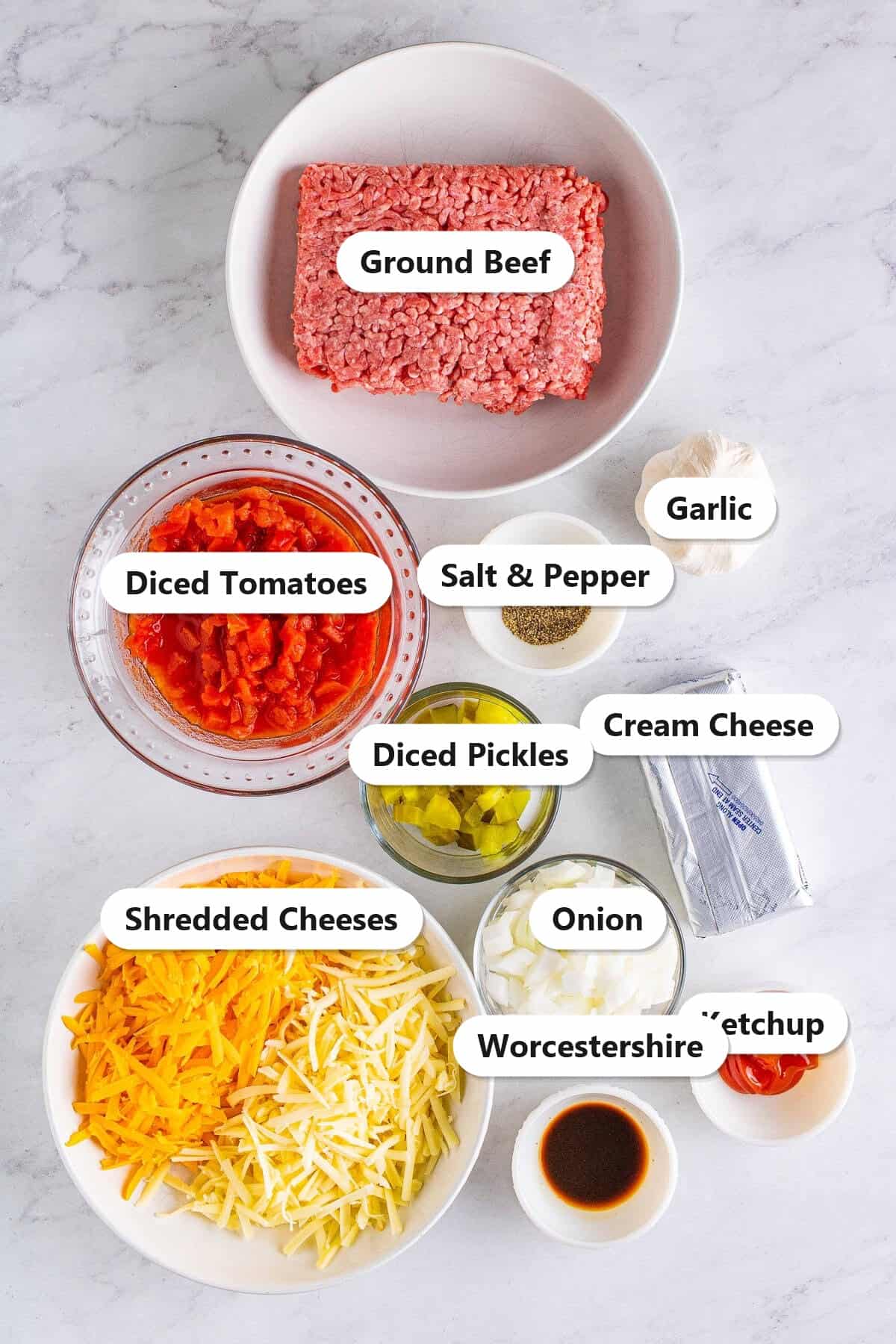 Labeled ingredients for dill pickle cheeseburger dip including ground beef, tomatoes, pickles, cheeses, and cream cheese.