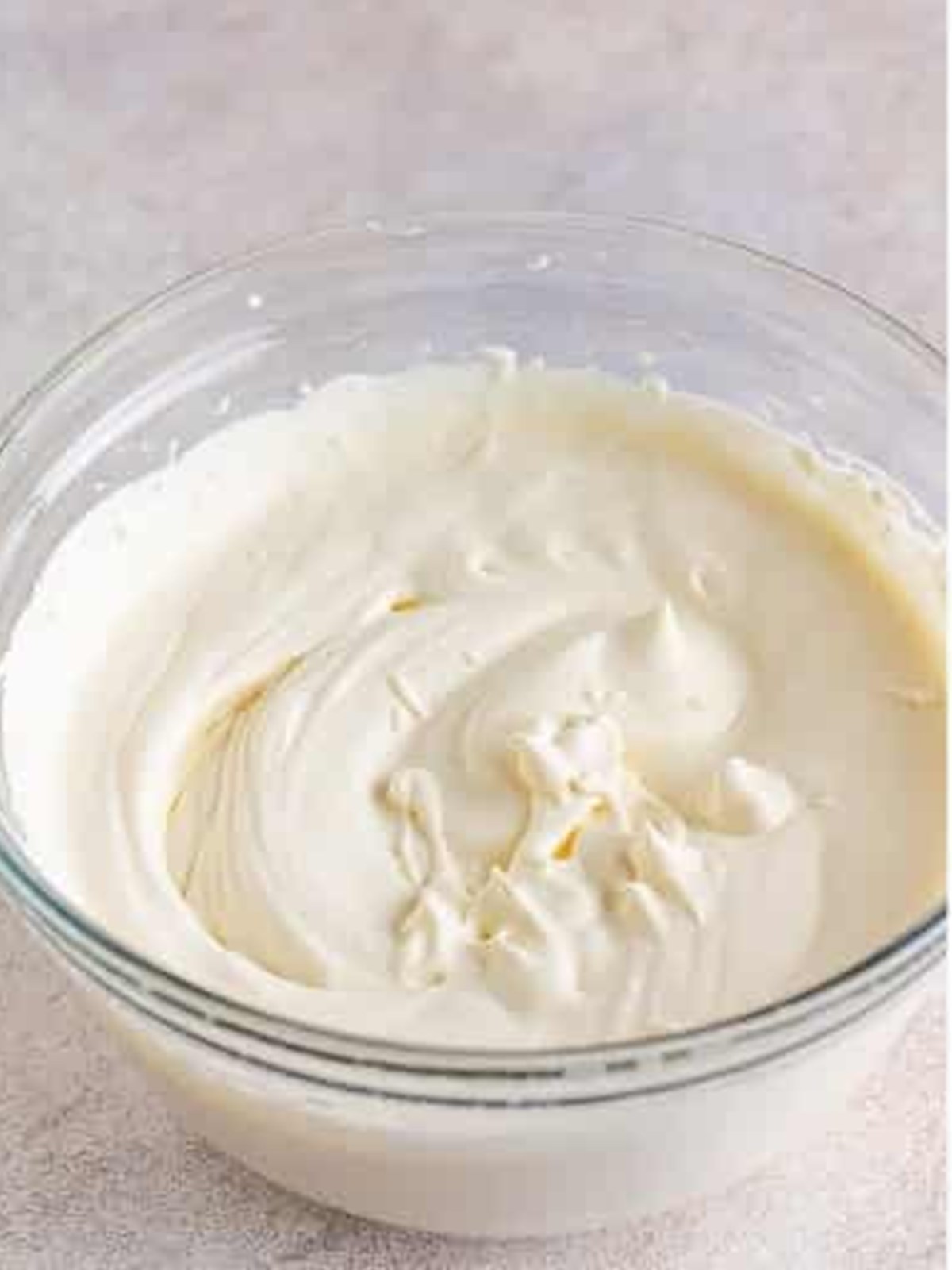 Heavy cream whipped to stiff peaks in a glass bowl for dirt cake.