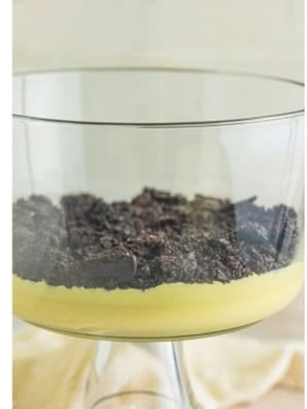 A layer of crushed Oreos over vanilla pudding in a trifle dish for dirt cake.
