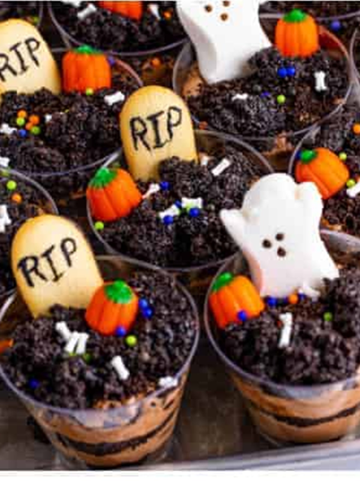 Decorated Halloween dirt cups with RIP Milano tombstones, ghost Peeps, and pumpkin candies.
