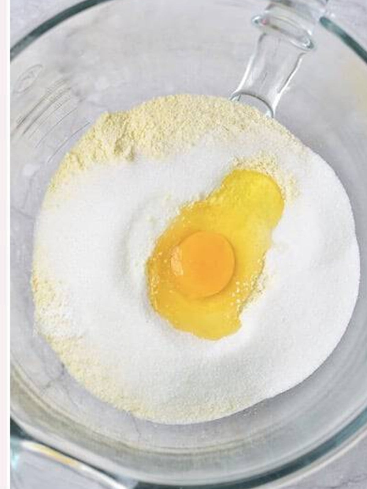 Adding the egg to the sandy butter and flour mixture.