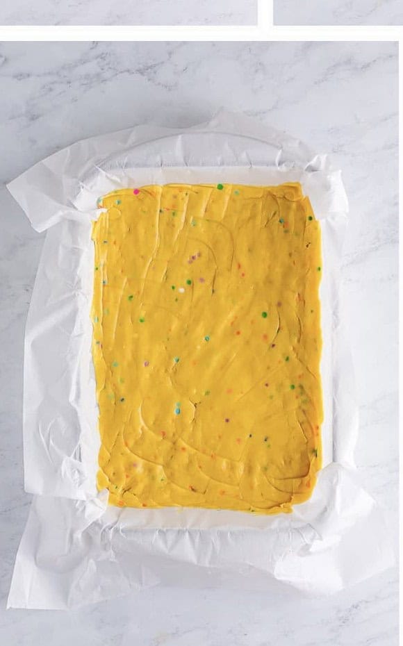 Easter Cookie Bar batter pressed into a parchment lined baking dish.