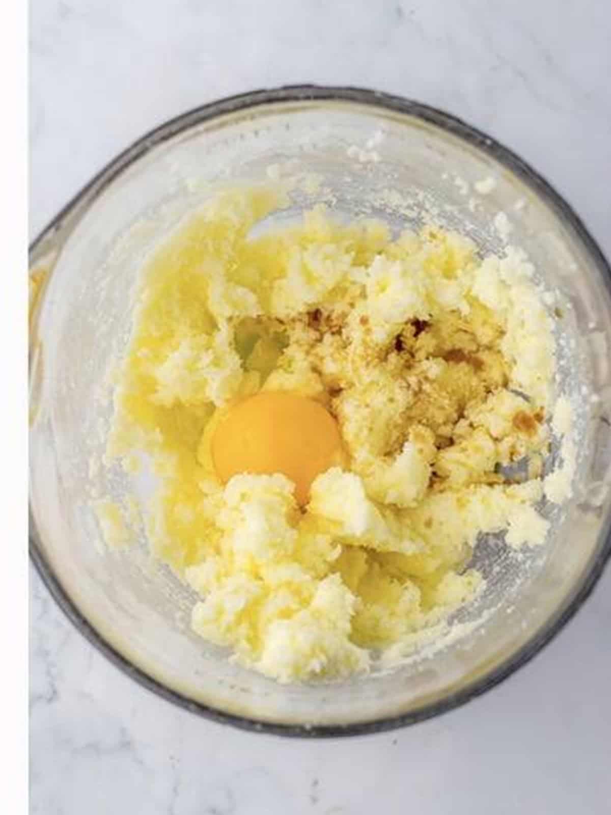 Egg and vanilla extract added to the creamed butter and sugar for Easter sugar cookie dough.