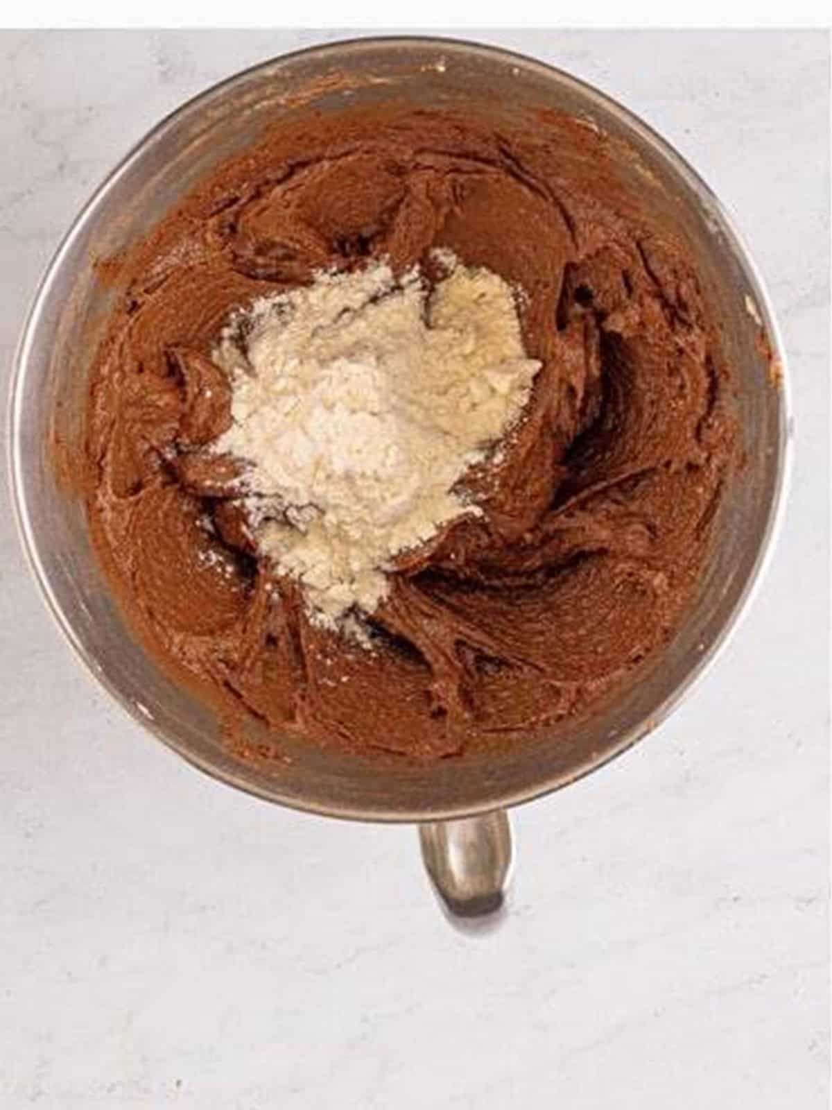 Heat treated flour and milk being mixed into chocolate cookie dough.