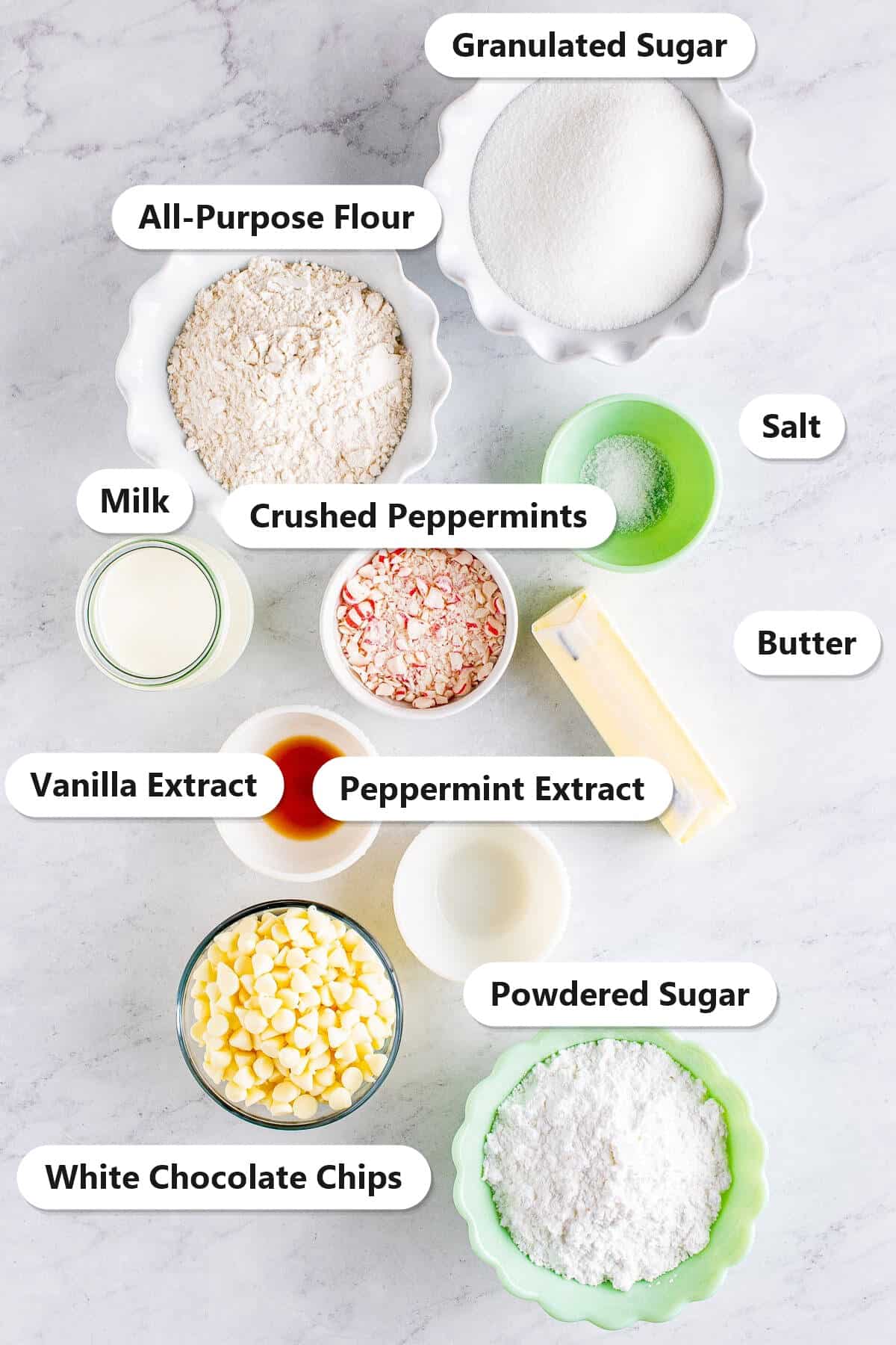 Labeled ingredients for edible sugar cookie dough including flour, granulated sugar, powdered sugar, butter, milk, white chocolate chips, and crushed peppermints.