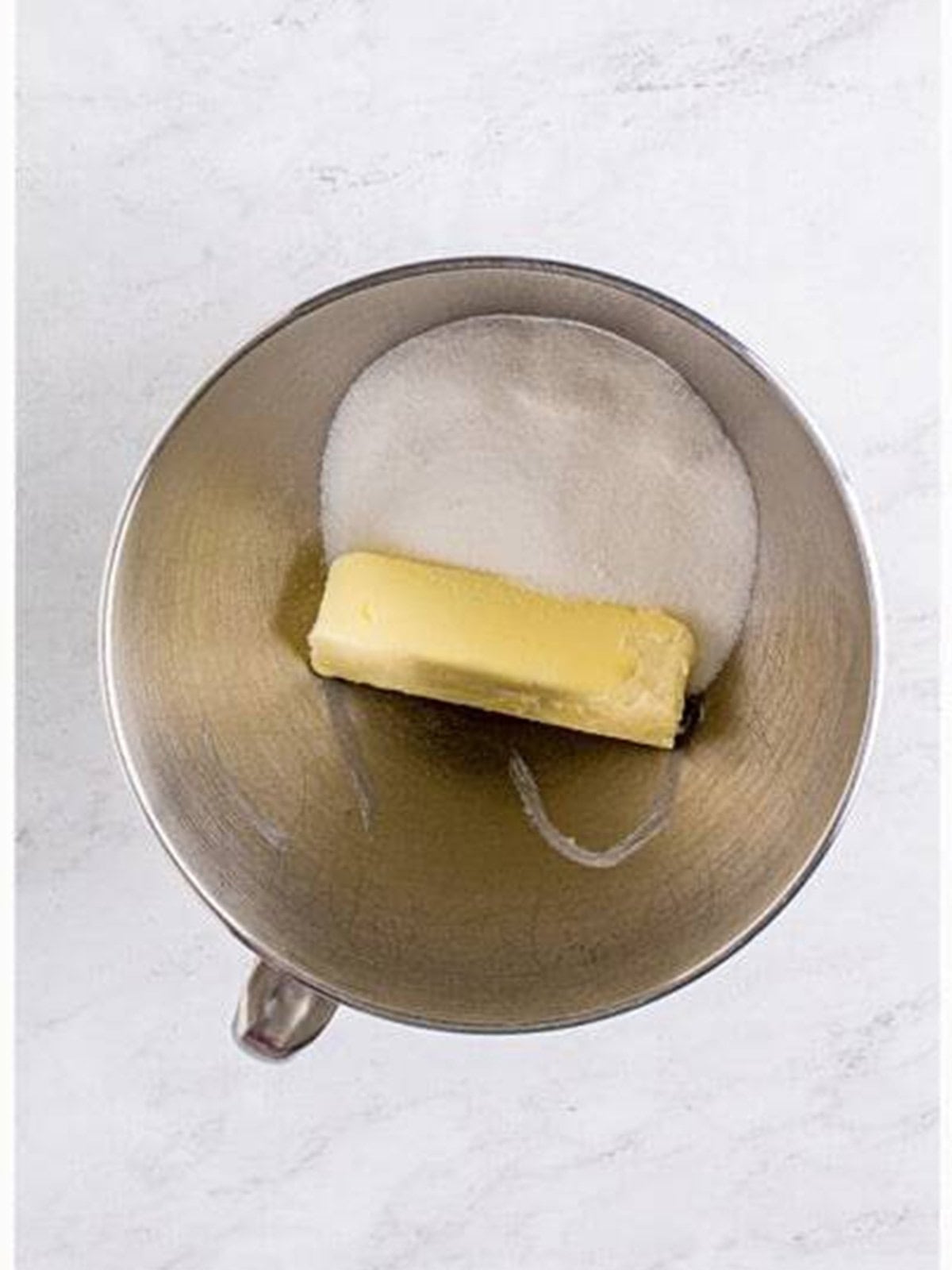 Butter and granulated sugar in a stand mixer bowl ready to cream together.