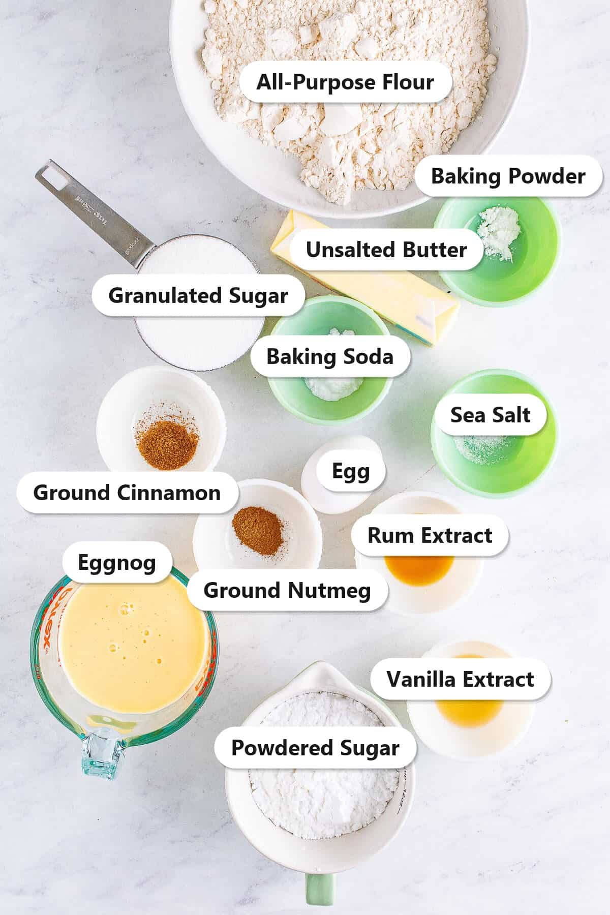 Labeled ingredients for eggnog bread including flour, sugar, butter, eggnog, egg, rum extract, vanilla, spices, and powdered sugar for the glaze.