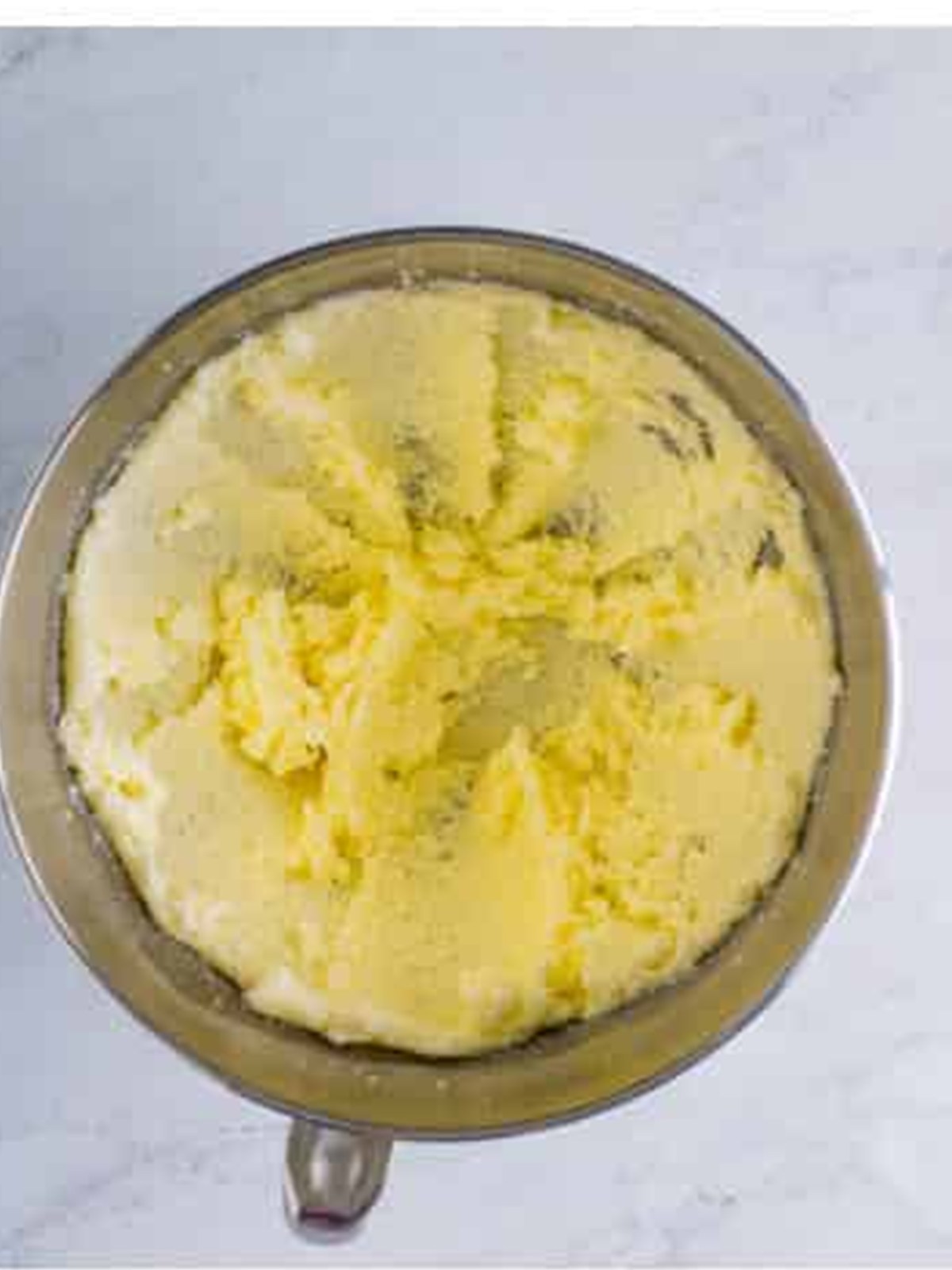 Butter and sugar creamed together in a stand mixer bowl for eggnog cake.
