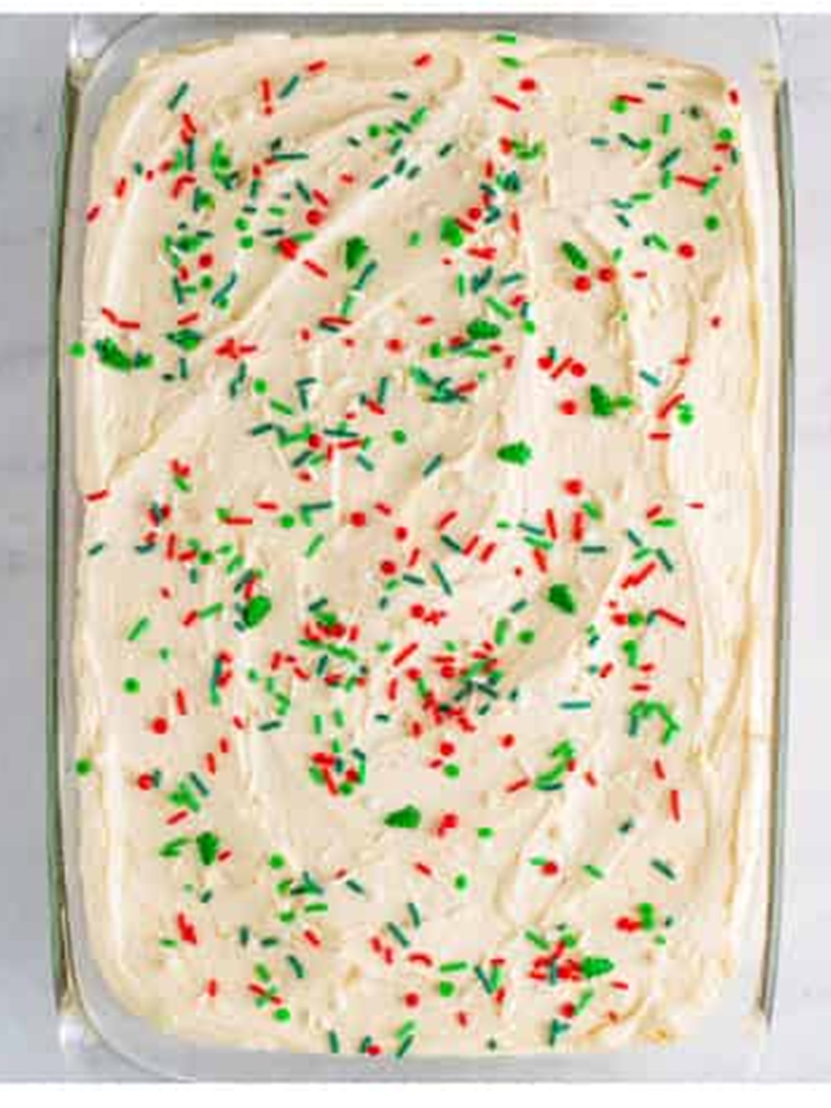 Eggnog frosting spread over the cooled cake and topped with Christmas sprinkles.