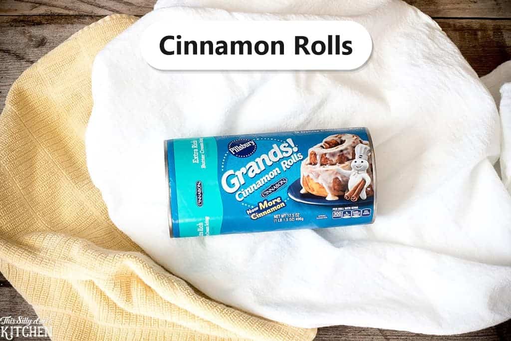 Pillsbury Grands cinnamon rolls, the star ingredient for eggnog cinnamon roll bread pudding, labeled on a kitchen towel.