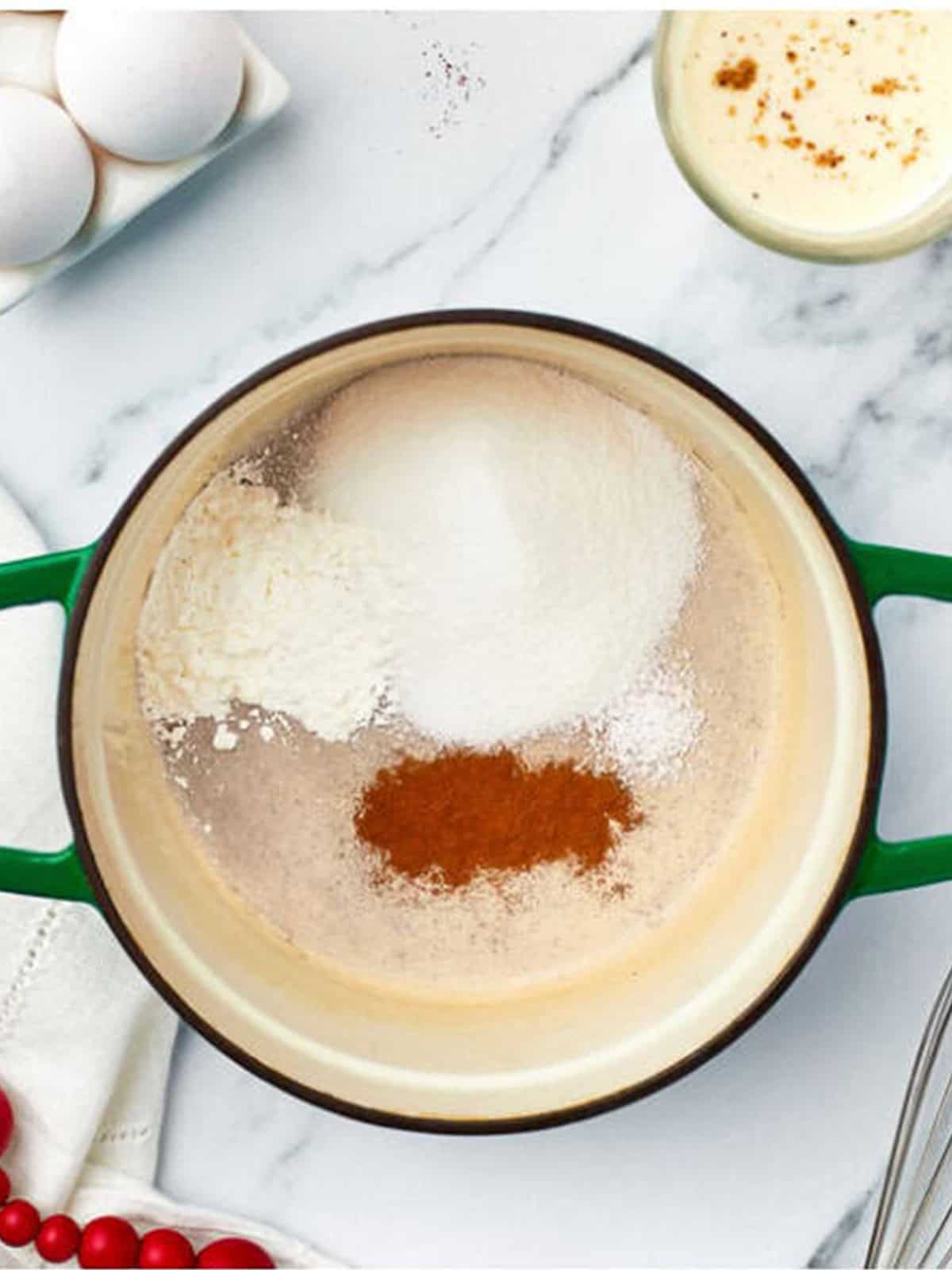 Sugar, cornstarch, salt, and cinnamon in a pot ready to whisk with eggnog for the pudding filling.