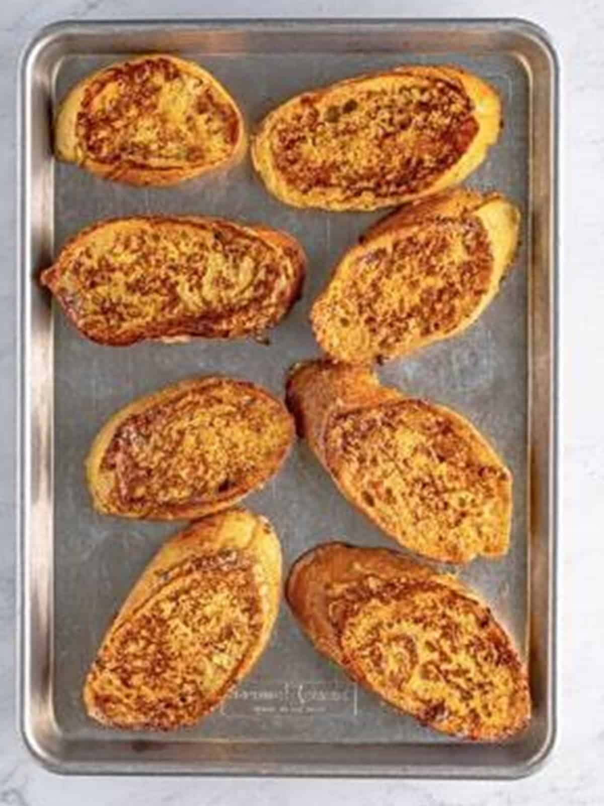Cooked eggnog french toast slices resting on a sheet tray.