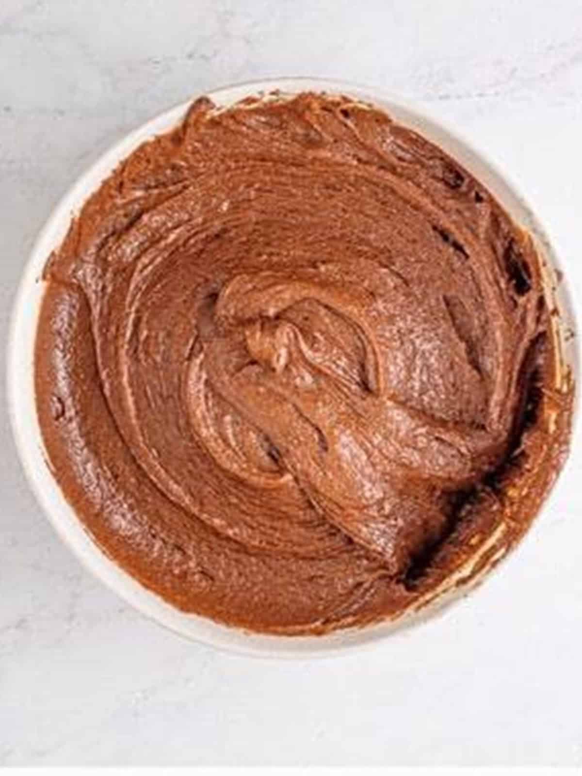 Thick chocolate brownie batter fully combined in a mixing bowl.