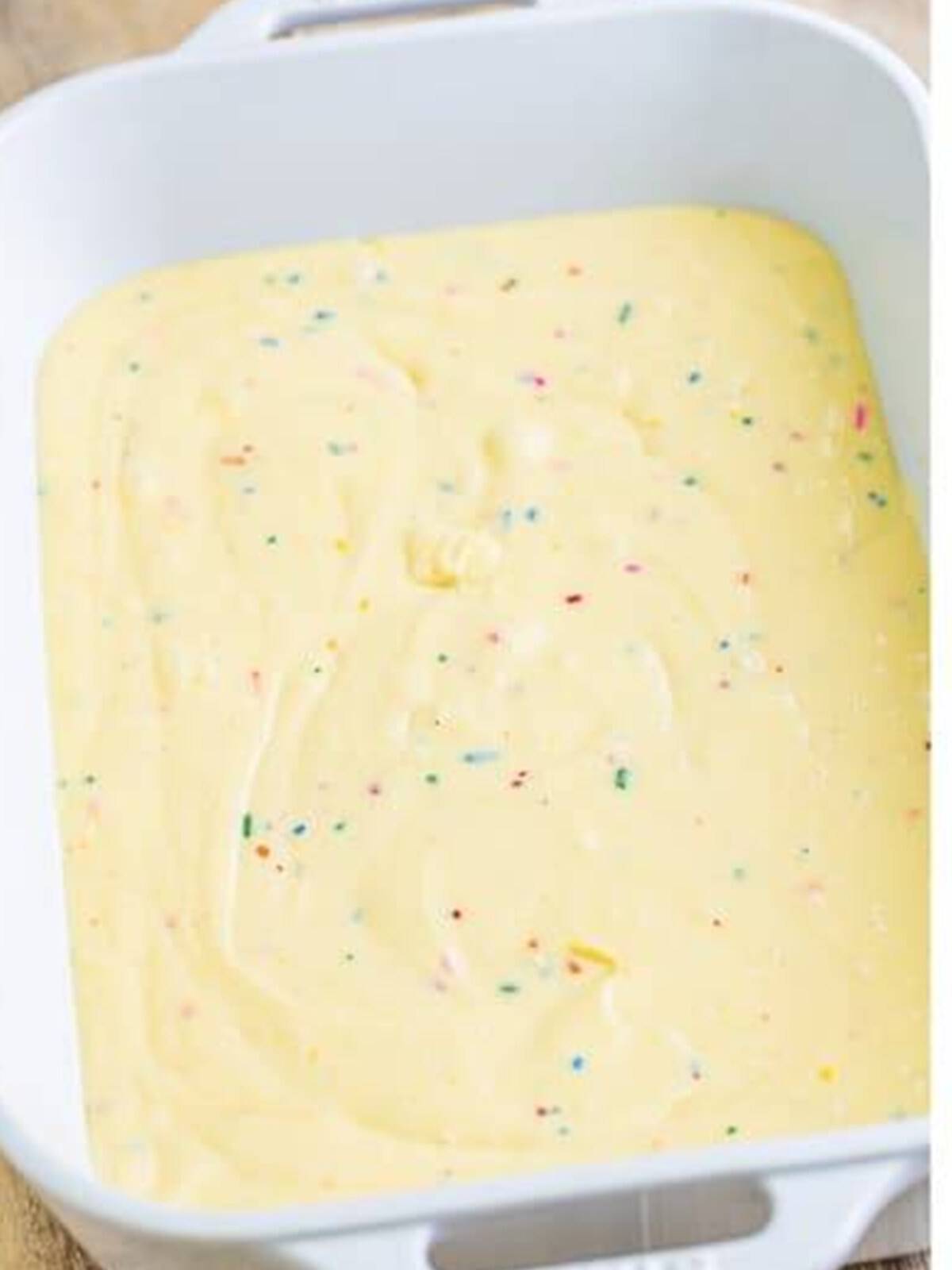 Funfetti cake batter spread in a baking pan.