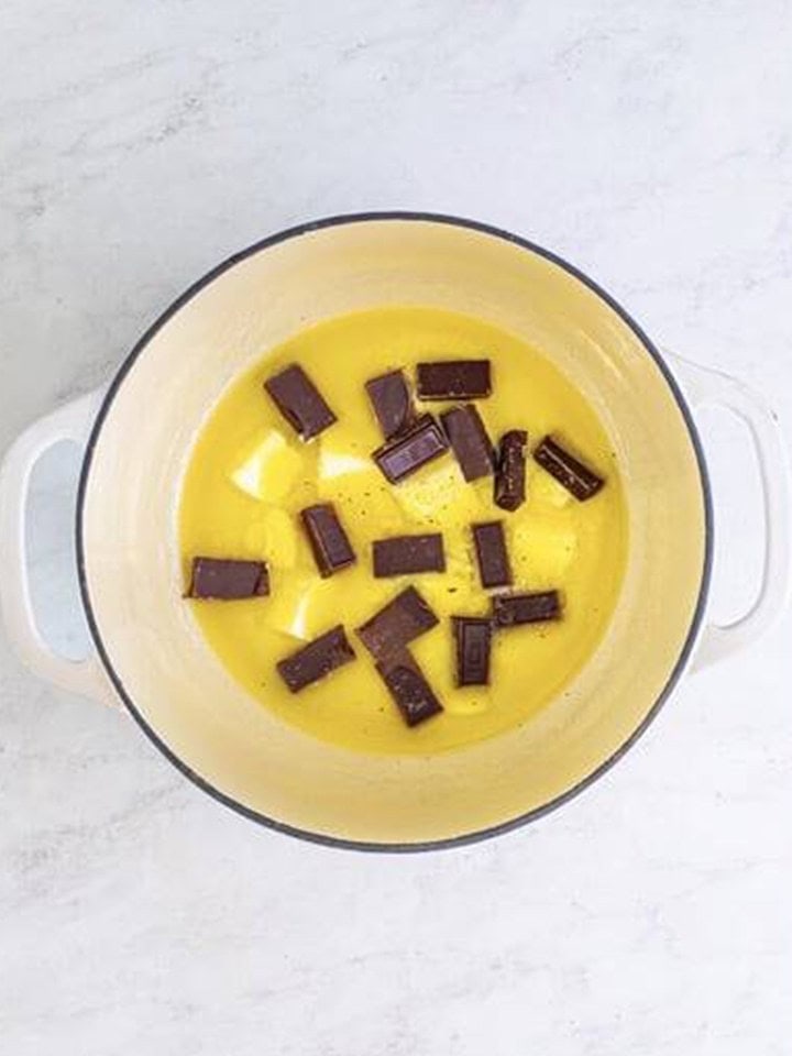 German chocolate baking bar squares melting into butter in a dutch oven.