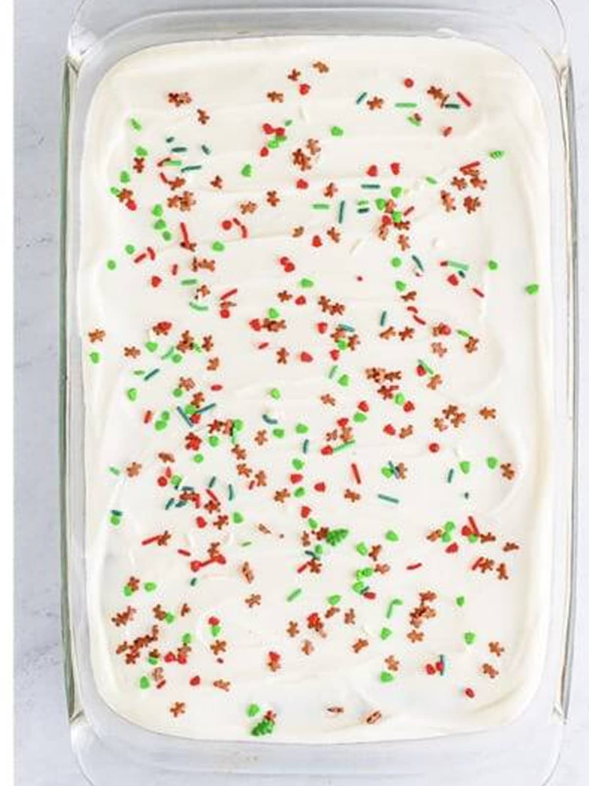 Gingerbread bars frosted with cream cheese frosting and topped with holiday sprinkles.