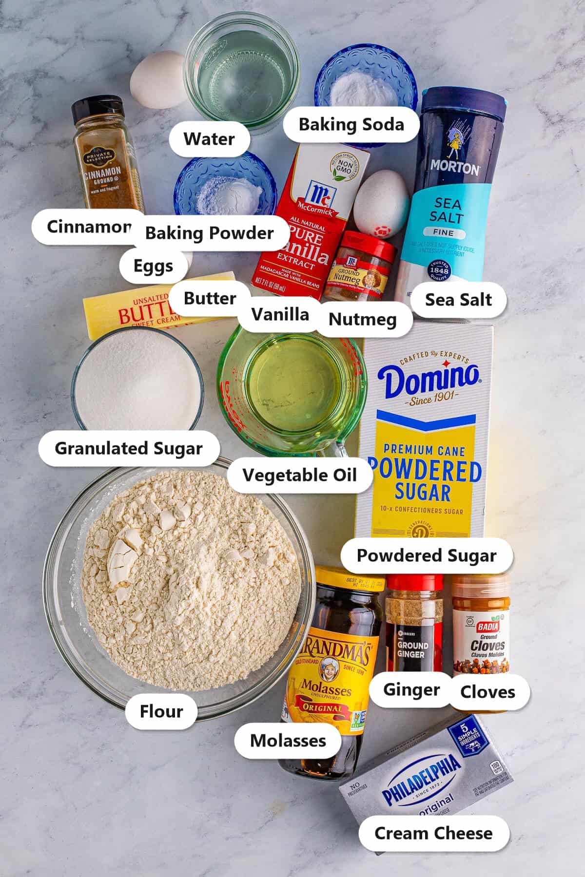 Labeled ingredients to make Gingerbread Cake: flour, molasses, spices, eggs, butter, oil, sugars, cream cheese, and vanilla.