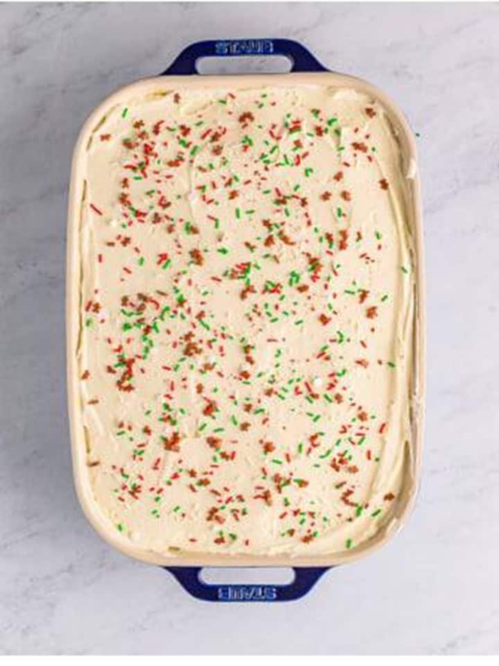 Cream cheese frosting spread over the cooled Gingerbread Cake with holiday sprinkles.