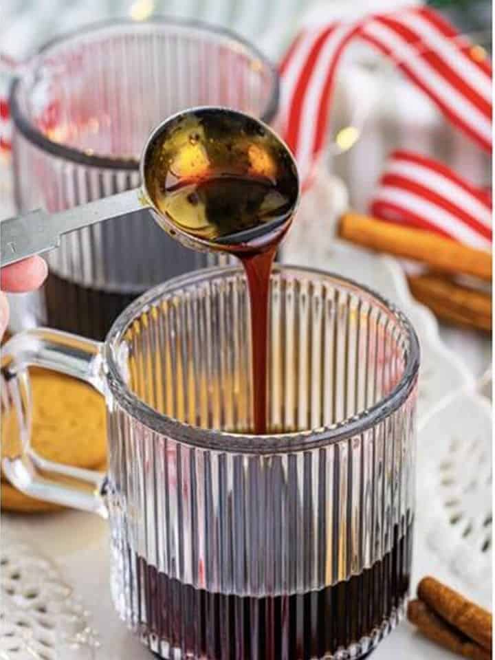 Pouring homemade gingerbread syrup into the espresso for a Gingerbread Latte.