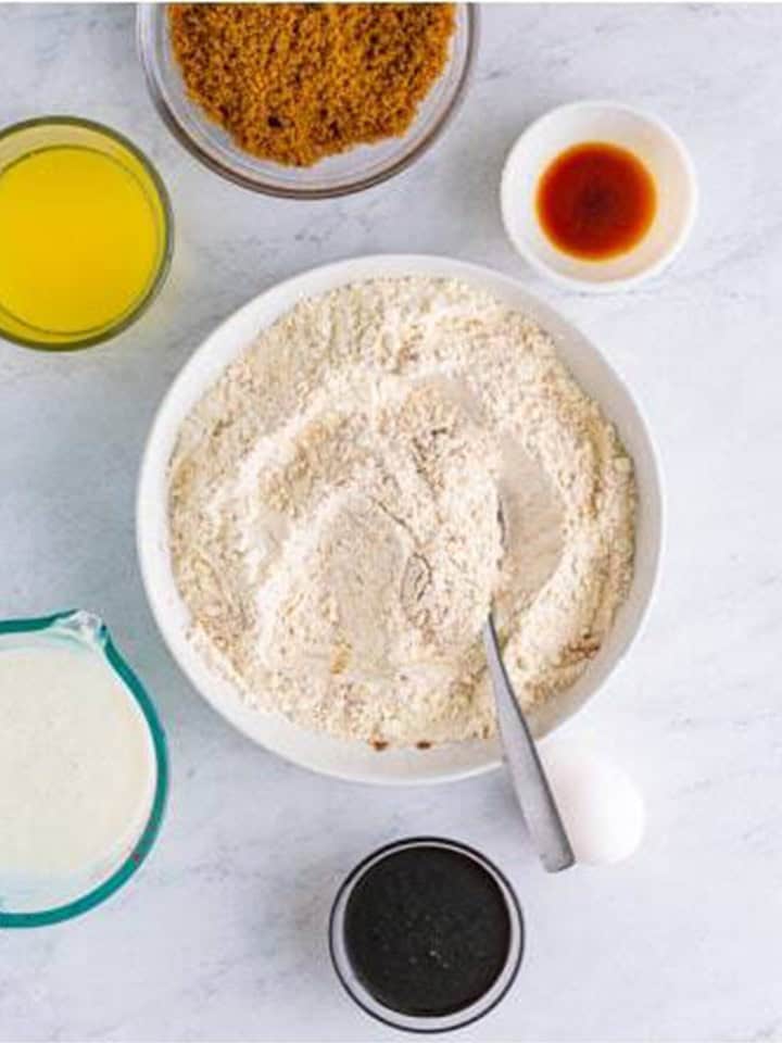 Flour and warm spices stirred together in a large bowl for gingerbread muffins.