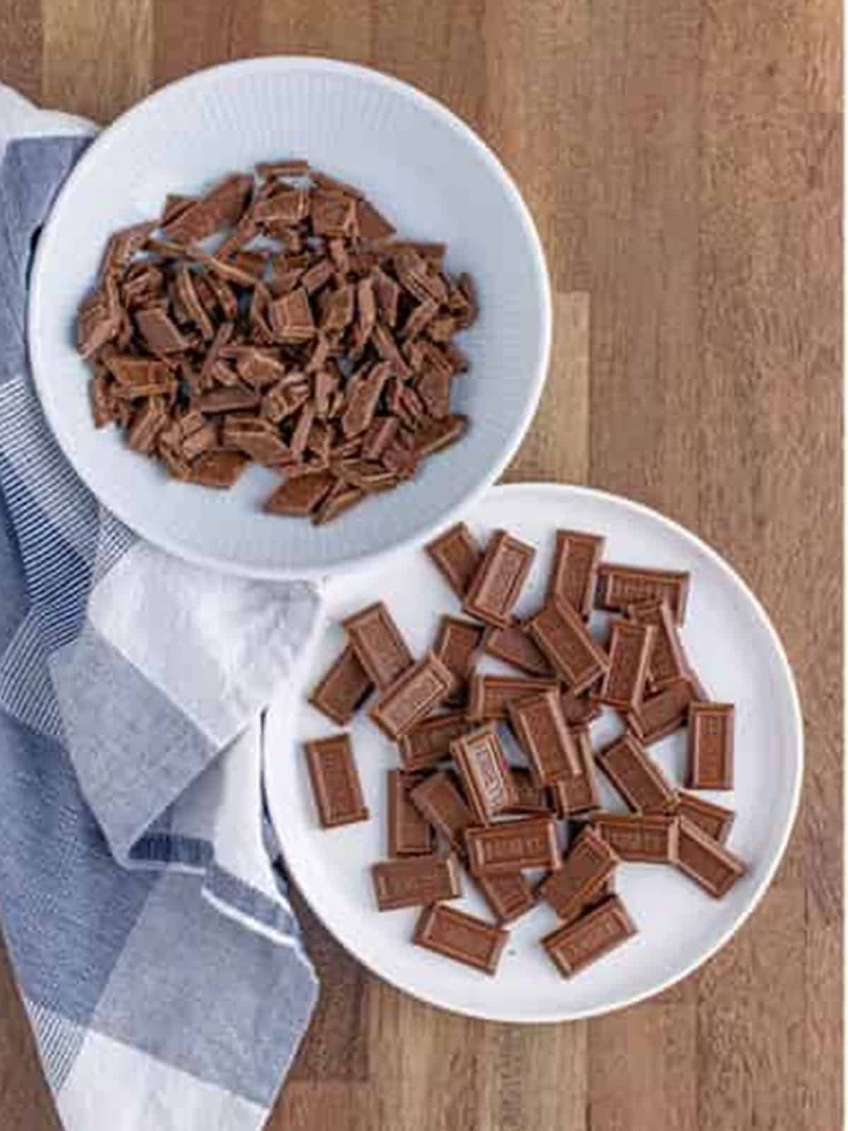 Hershey's milk chocolate bars chopped and broken into pieces on plates for golden grahams smores bars.