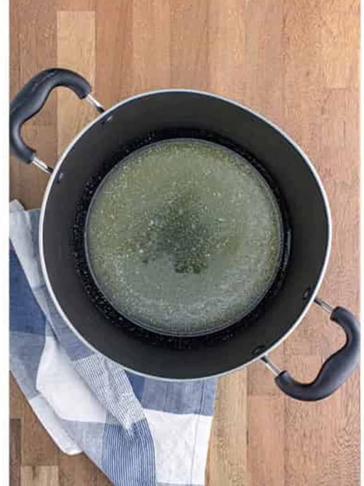 Salted butter melting in a large pot for golden grahams smores bars.