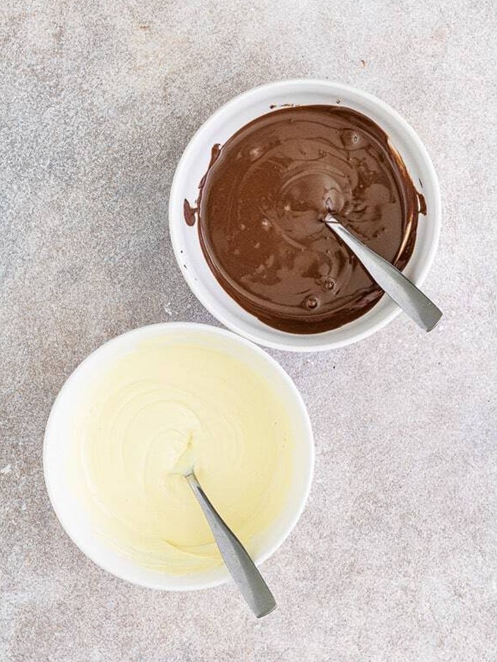 Chocolate and white chocolate candy melts melted in separate bowls for halloween bark.