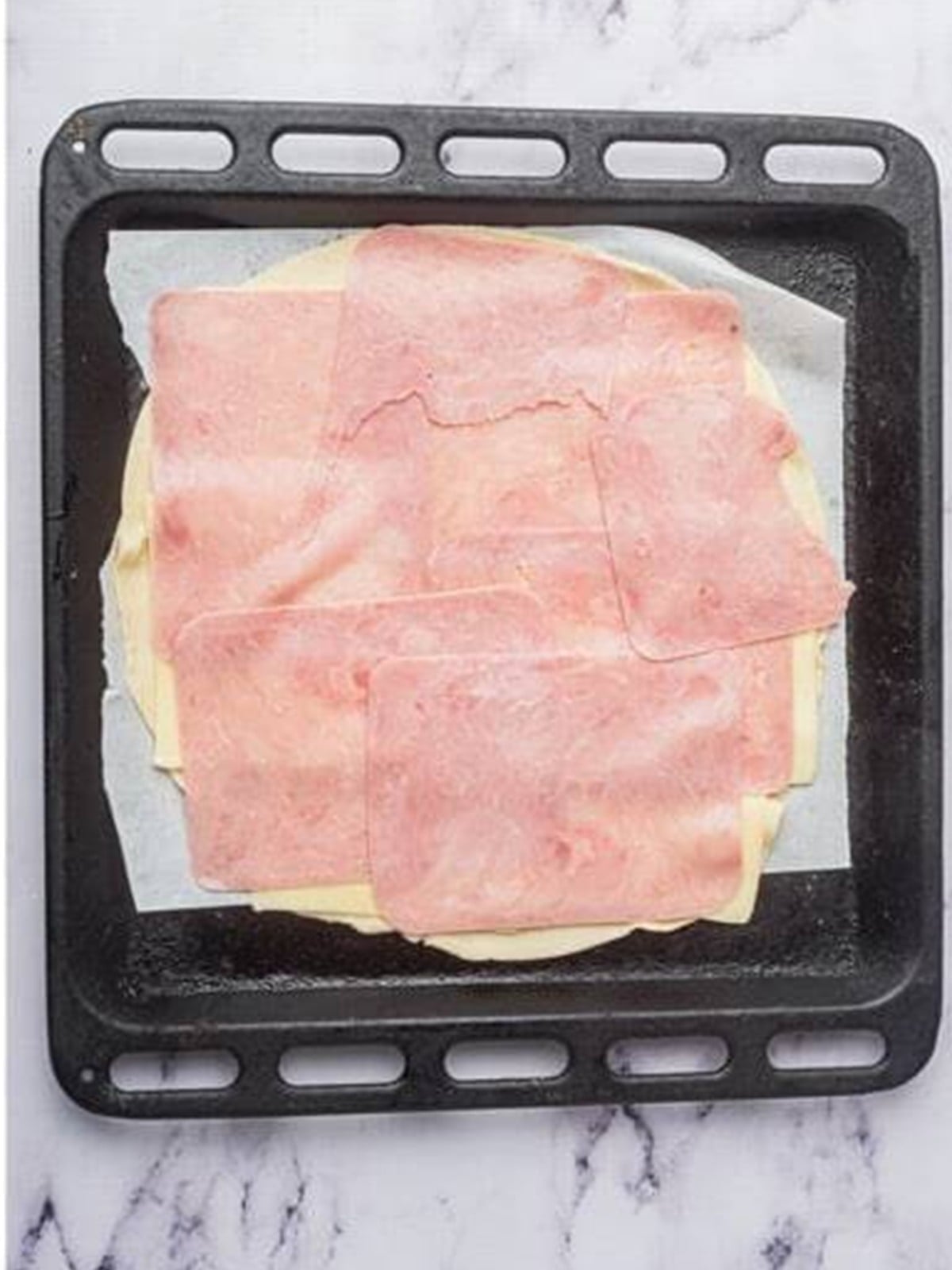 Adding a layer of sliced ham over the cheese for Ham and Cheese Bars.