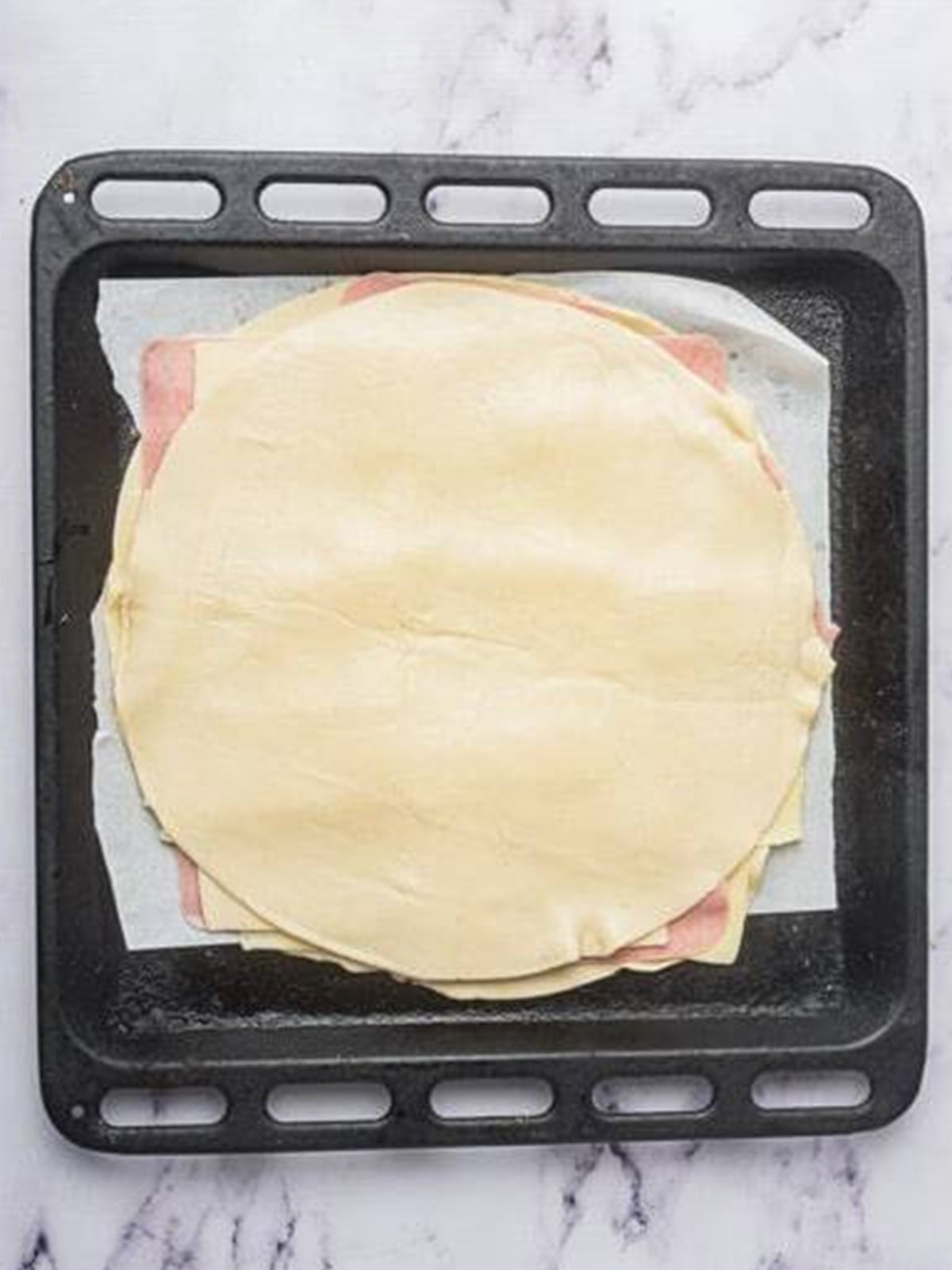 Topping the layers with a second sheet of pie crust for Ham and Cheese Bars.
