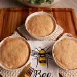 Two Chedz cheesy chicken pot pies with golden cheddar crusts on a Bee Kind kitchen towel.
