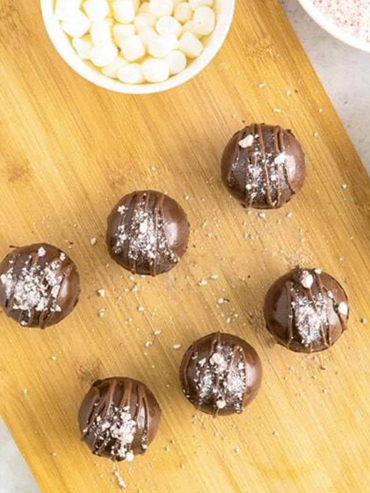 Finished Hot Cocoa Bombs drizzled with chocolate and sprinkled with crushed peppermint candy.
