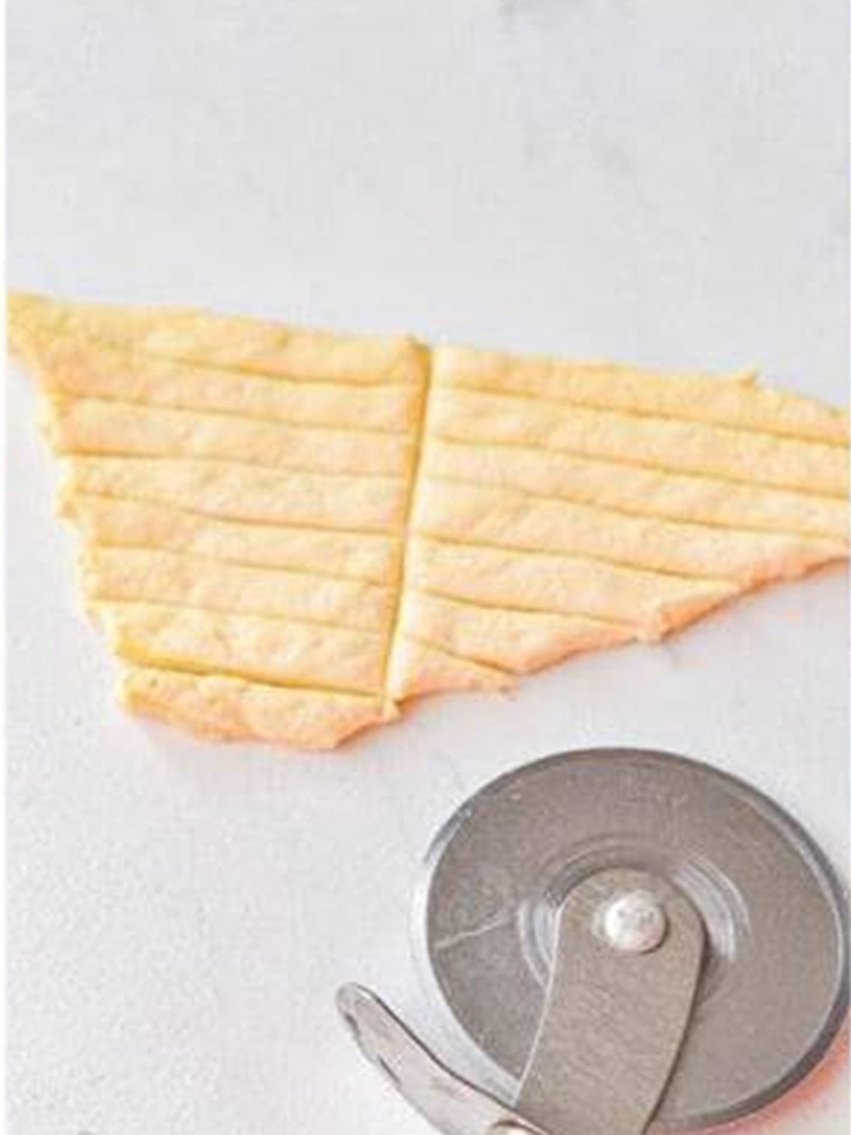 Crescent dough sliced into thin strips with a pizza cutter.